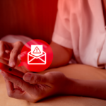 Pessoa segurando um smartphone vermelho com as duas mãos enquanto visualiza a tela do aparelho. Sobre a imagem há um ícone gráfico de mensagem eletrônica com símbolo de alerta em destaque, representando aviso, golpe digital, spam ou comunicação suspeita. A cena possui iluminação em tons avermelhados, com foco nas mãos e no celular. No canto superior esquerdo há um pequeno logotipo branco dentro de um quadrado com cantos arredondados. Forneça seus comentários sobre o BizChat